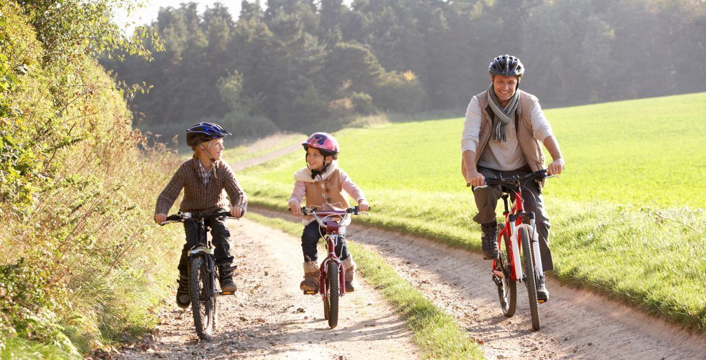 Barn med förälder som cyklar