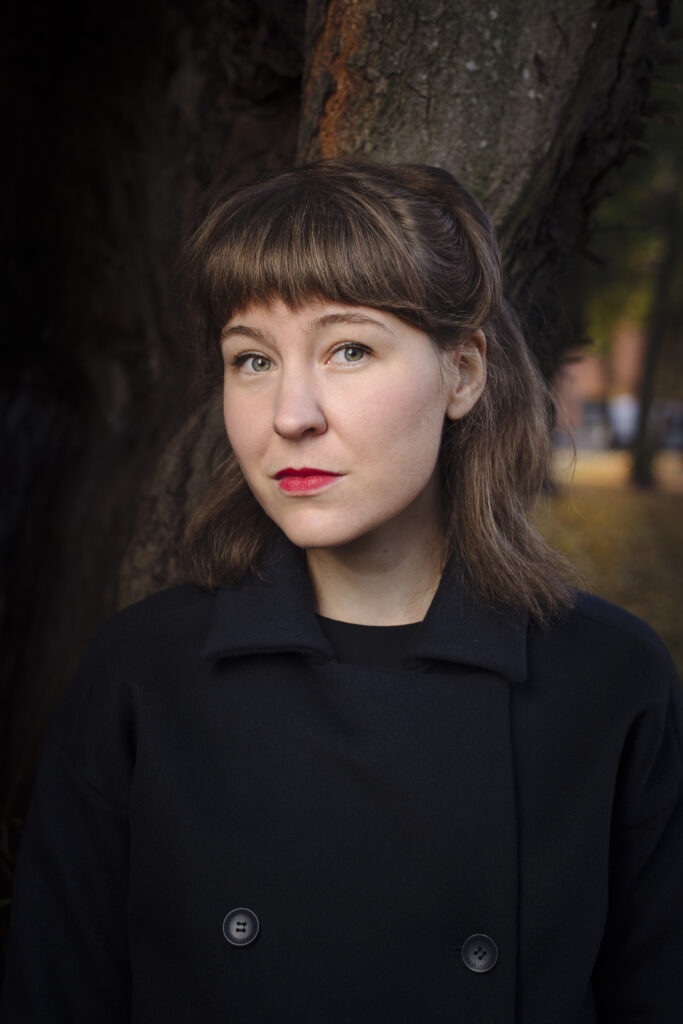 Kvinna framför ett träd.